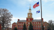 Exterior shot of Howard University building with American and university flags flying in the foreground.