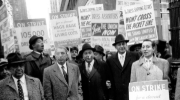 Black and white photo of a group of dressmakers on strike hold signs urging unionization and fair labor practices in 1958. Credit: Kheel Center via Flickr, image ID 5780PB36F10D