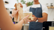 Customer holding tray of coffee to go order.