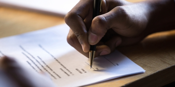 Close-up of a hand signing a document