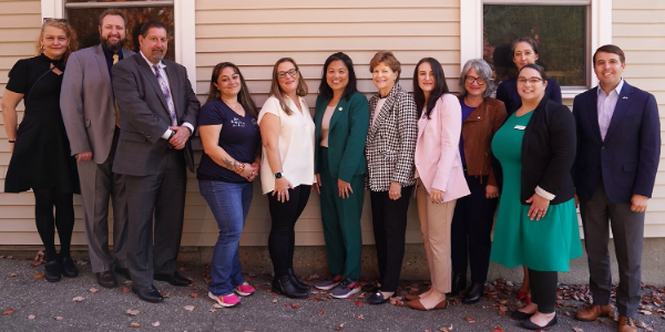 Acting Secretary Su with 11 other people outside a childcare center, including Sen. Jeanne Shaheen and Rep. Chris Pappas.