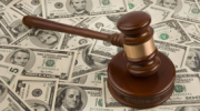 A gavel sits on a pile of dollars.