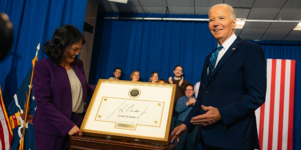 Acting Secretary Su shows President Biden a Lucite plaque bearing his signature and a department seal for his induction into the Labor Hall of Honor.