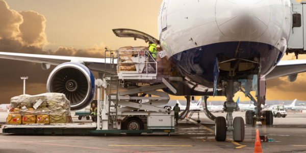 Loading cargo on the plane in airport, view through window