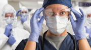 Healthcare workers wearing PPE walking down a hallway.