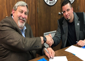 OSHA Acting Area Director Luis Ramos-Morales and AGC Executive Director Perry Vaughn sign an alliance renewal to continue protecting employees in the construction industry.