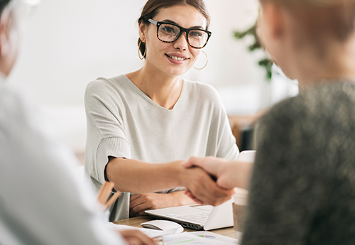 Woman shaking hands with employer after an interview.