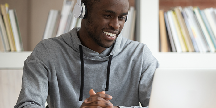 Man with headphones on a laptop looking for online classes.