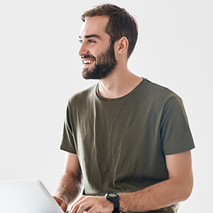 Veteran working on a laptop with a smile.