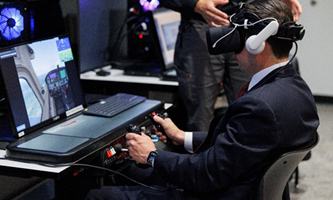 Acting Secretary Sonderling wears an AI headset while testing a training program on a computer.