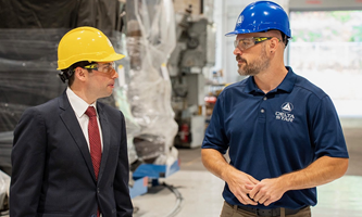 Acting Secretary Keith Sonderling speaks with a worker in a manufacturing facility.