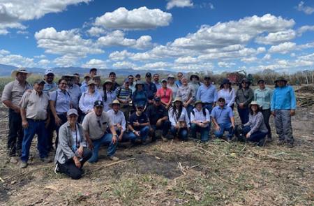 A group of people, including ILAB staff and our partners, pose for a group photo in an open field in El Salvador as part of a data collection trip.