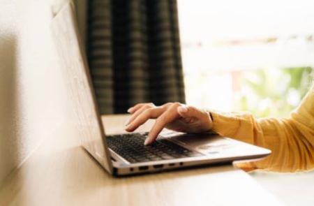 Hand typing at a laptop